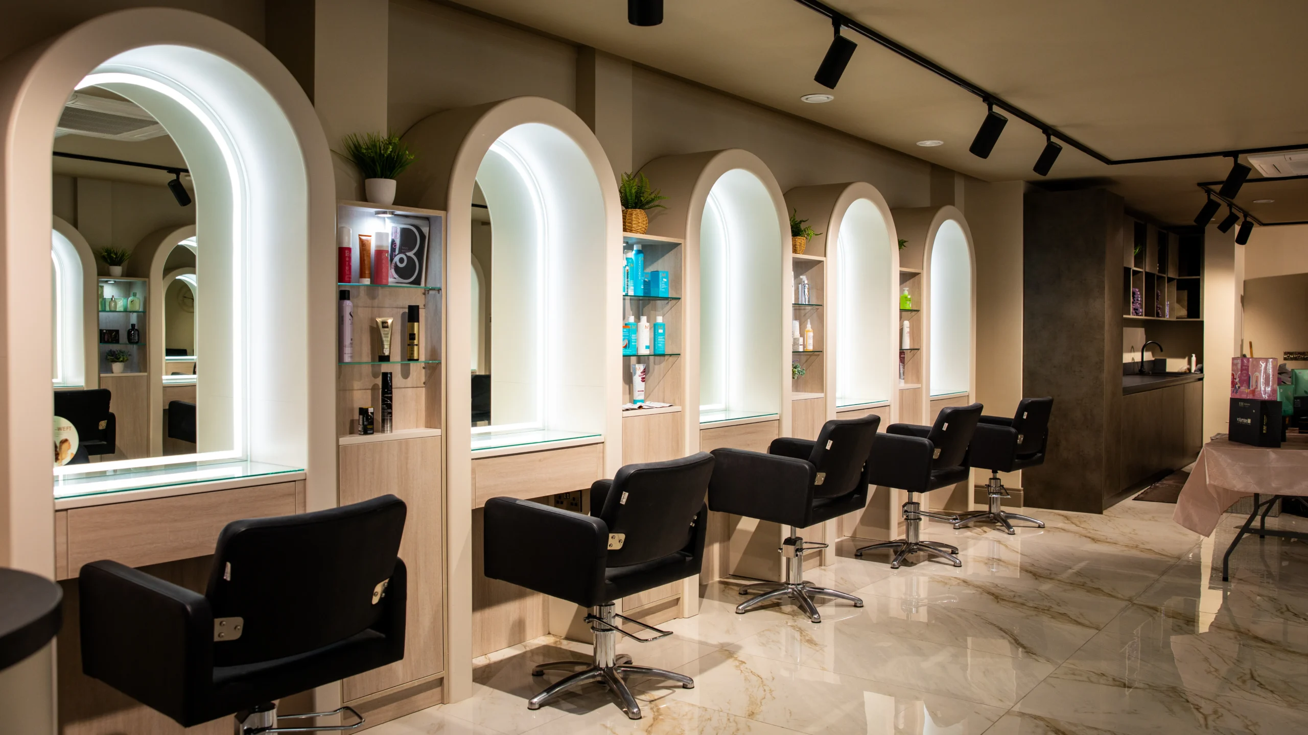 Completed salon fit-out with arched illuminated mirror bays and timber cabinetry